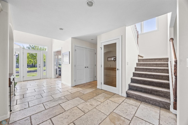 entrance foyer featuring stone tile floors, healthy amount of natural light, stairway, recessed lighting, and baseboards