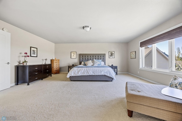 bedroom with light carpet and baseboards