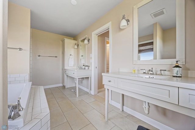 full bath featuring a garden tub, vanity, tile patterned floors, and baseboards