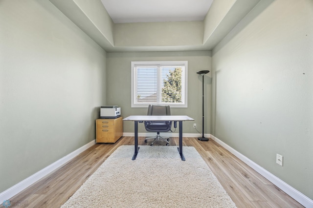 home office with light wood-type flooring and baseboards