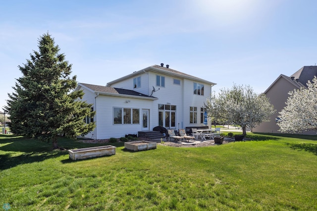 back of house featuring a patio area, a yard, and a fire pit
