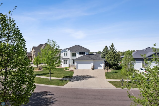 traditional home with an attached garage, concrete driveway, and a front lawn