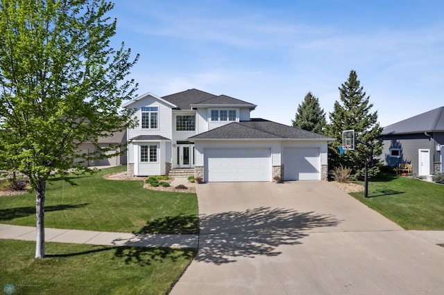 traditional home with stone siding, an attached garage, concrete driveway, a front yard, and roof with shingles