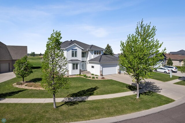 view of front of house with driveway, an attached garage, and a front lawn