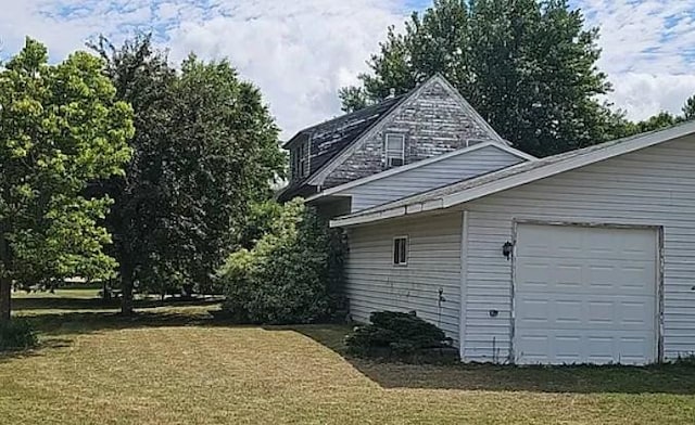 view of property exterior featuring a garage and a yard