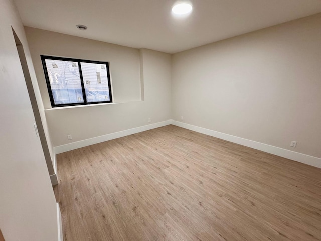 unfurnished room with baseboards and wood finished floors