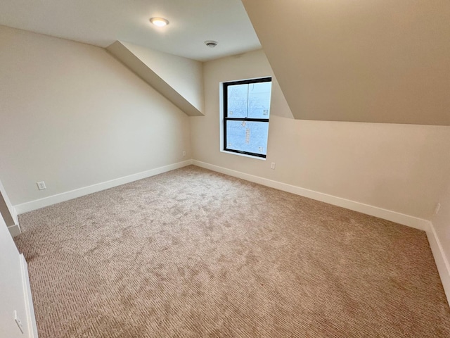 additional living space featuring baseboards, carpet, and vaulted ceiling