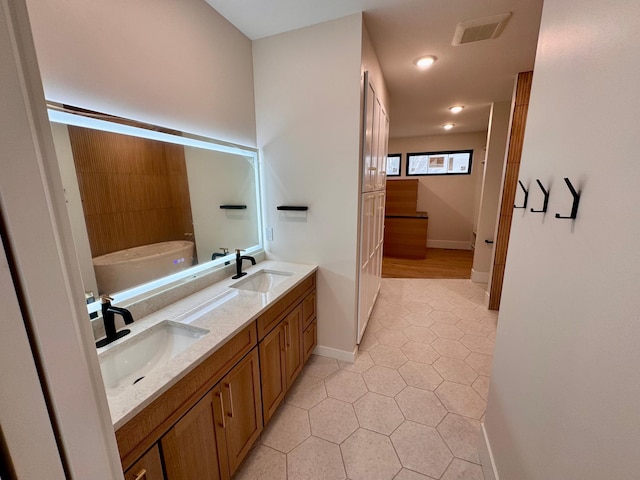 full bathroom featuring a sink, tile patterned flooring, double vanity, and visible vents