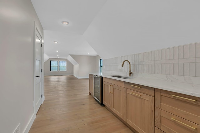 11694 Indian Beach Rd, Spicer, MN 56288 - kitchen with wine cooler, open floor plan, vaulted ceiling, light wood-type flooring, and light stone counters