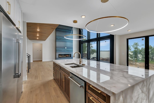 11694 Indian Beach Rd, Spicer, MN 56288 - kitchen featuring stainless steel appliances, plenty of natural light, light wood finished floors, recessed lighting, and light stone countertops