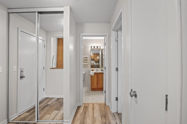 3729 Snelling Ave Unit 203, Minneapolis, MN 55406 - hall with light wood-type flooring, baseboards, and a textured ceiling