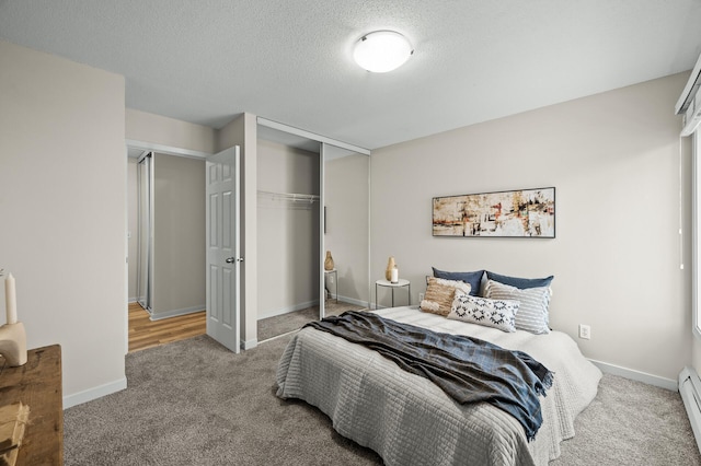 3729 Snelling Ave Unit 203, Minneapolis, MN 55406 - carpeted bedroom featuring baseboard heating, a closet, baseboards, and a textured ceiling