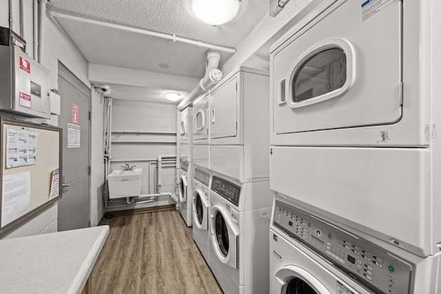 3729 Snelling Ave Unit 203, Minneapolis, MN 55406 - common laundry area featuring washer and dryer, a textured ceiling, wood finished floors, and stacked washer and clothes dryer