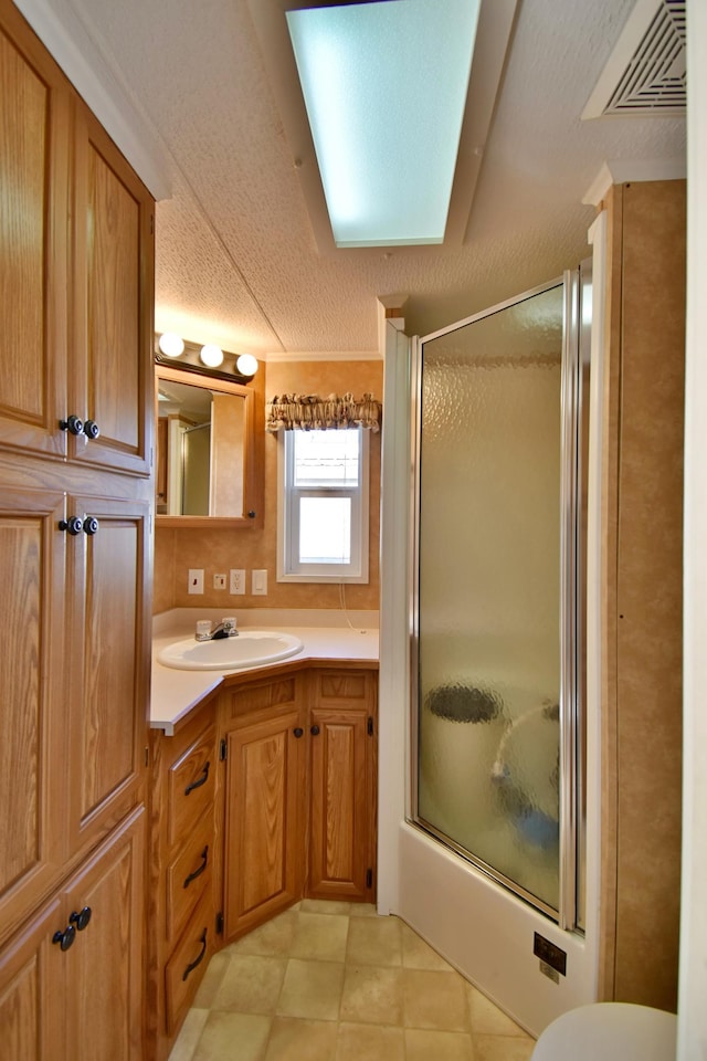 18096 Browns Lake Rd # 17, Richmond, MN 56368 - bathroom with a textured ceiling, visible vents, bath / shower combo with glass door, vanity, and tile patterned flooring