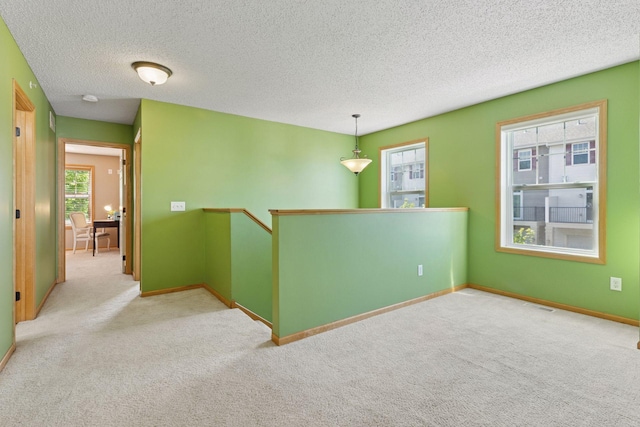 9512 Scott Ln N, Brooklyn Park, MN 55443 - carpeted empty room with plenty of natural light, baseboards, and a textured ceiling