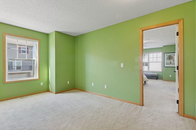 9512 Scott Ln N, Brooklyn Park, MN 55443 - spare room with a textured ceiling, carpet flooring, and baseboards