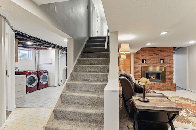 stairway featuring separate washer and dryer, a fireplace, and recessed lighting