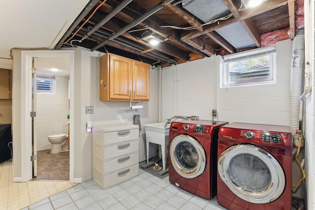 laundry room with cabinet space, washer and clothes dryer, and light tile patterned floors