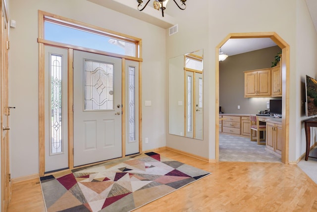 11871 Flanders Cir NE, Blaine, MN 55449 - foyer featuring light wood finished floors, arched walkways, and a chandelier