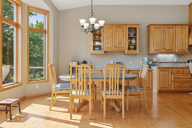 11871 Flanders Cir NE, Blaine, MN 55449 - dining area featuring vaulted ceiling, a chandelier, and light wood-style floors