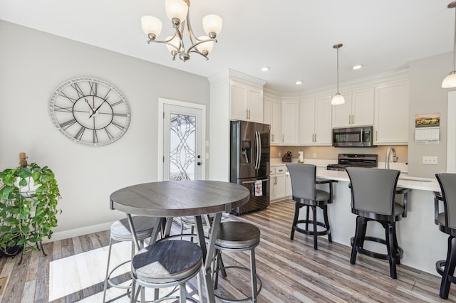3344 26th Ave S, Saint Cloud, MN 56301 - dining area featuring light wood-style floors, a chandelier, recessed lighting, and baseboards