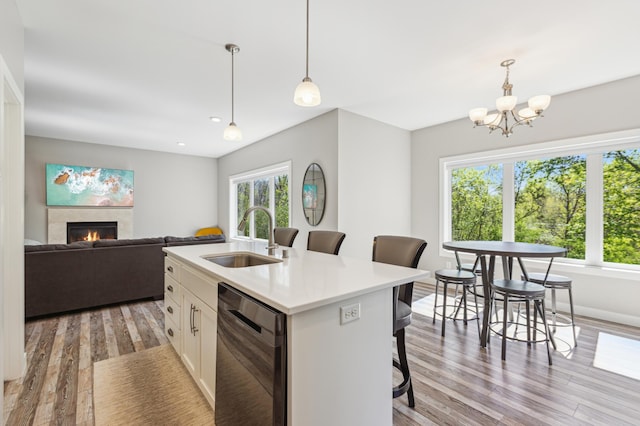 3344 26th Ave S, Saint Cloud, MN 56301 - kitchen featuring a sink, dishwashing machine, light wood-type flooring, white cabinetry, and a breakfast bar area