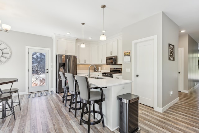 3344 26th Ave S, Saint Cloud, MN 56301 - kitchen with appliances with stainless steel finishes, a sink, light wood finished floors, a kitchen breakfast bar, and light countertops