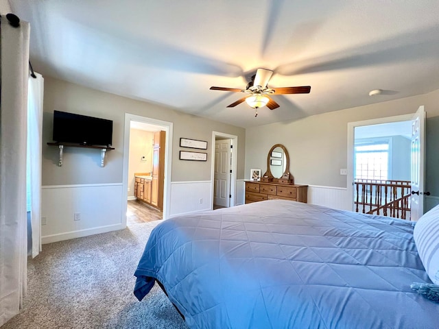 2543 Sunny Meadow Ln, Red Wing, MN 55066 - bedroom featuring wainscoting, light carpet, connected bathroom, and ceiling fan