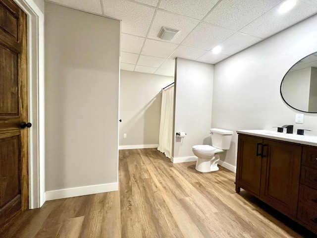 2543 Sunny Meadow Ln, Red Wing, MN 55066 - bathroom with a drop ceiling, toilet, vanity, wood finished floors, and baseboards