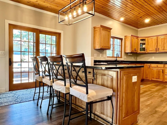 2543 Sunny Meadow Ln, Red Wing, MN 55066 - kitchen with wooden ceiling, ornamental molding, dark countertops, wood finished floors, and glass insert cabinets