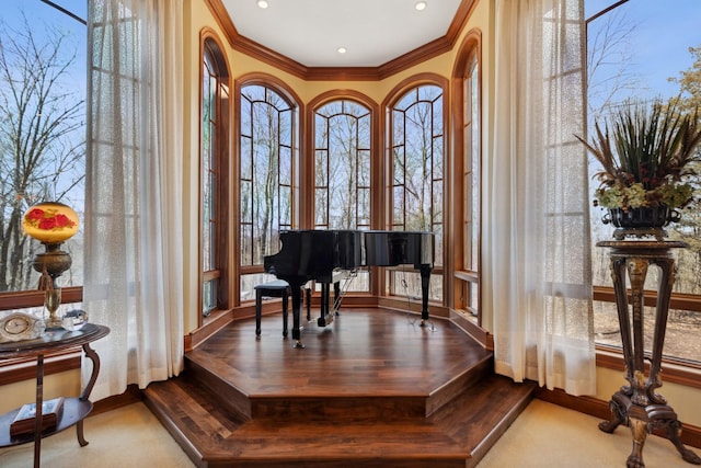 living area featuring crown molding, baseboards, and wood finished floors