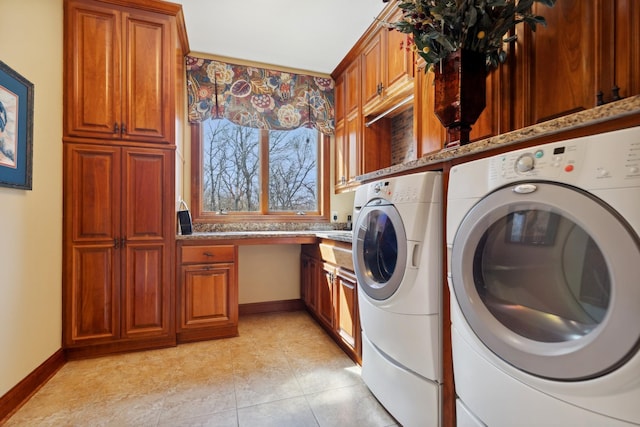 clothes washing area featuring baseboards, washer and clothes dryer, cabinet space, and light tile patterned floors