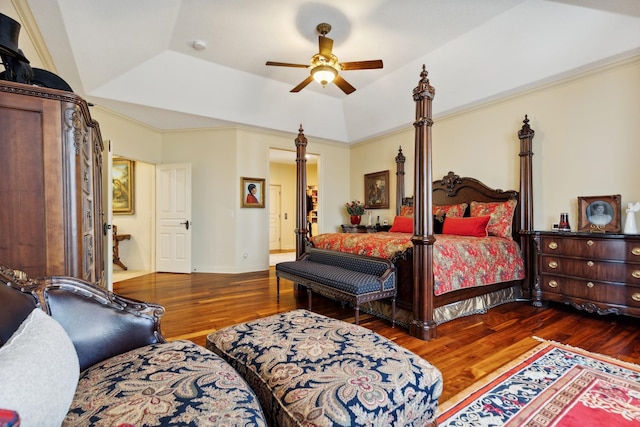bedroom with baseboards, ceiling fan, wood finished floors, and a raised ceiling