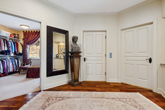 foyer entrance featuring baseboards, ornamental molding, and wood finished floors