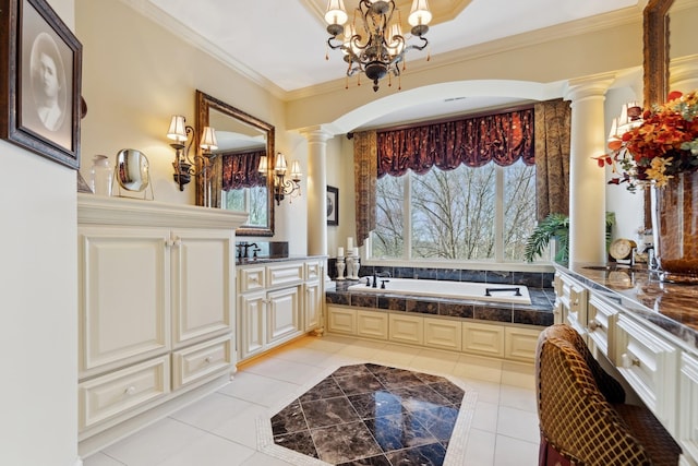 bathroom with a notable chandelier, tile patterned flooring, ornate columns, ornamental molding, and a garden tub