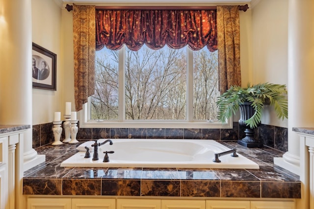 bathroom featuring ornate columns and a bath