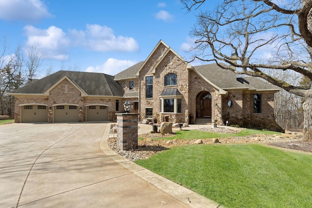 french country style house featuring a garage, a front yard, brick siding, a shingled roof, and driveway