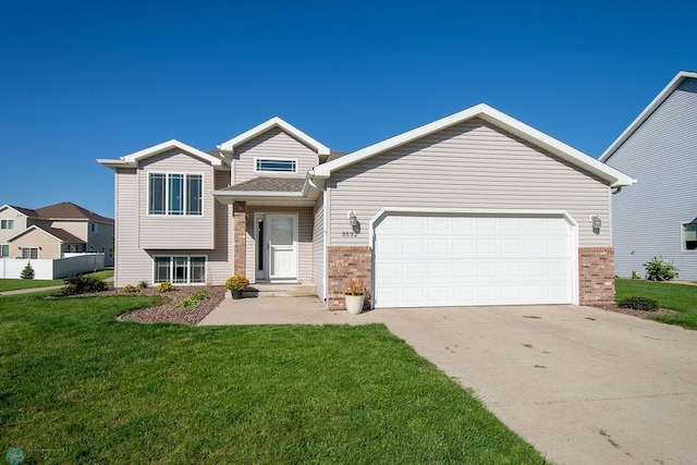 split level home with a front lawn, driveway, an attached garage, and brick siding
