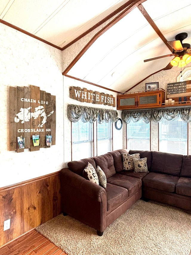 living room with vaulted ceiling with beams, wood finished floors, ceiling fan, and ornamental molding