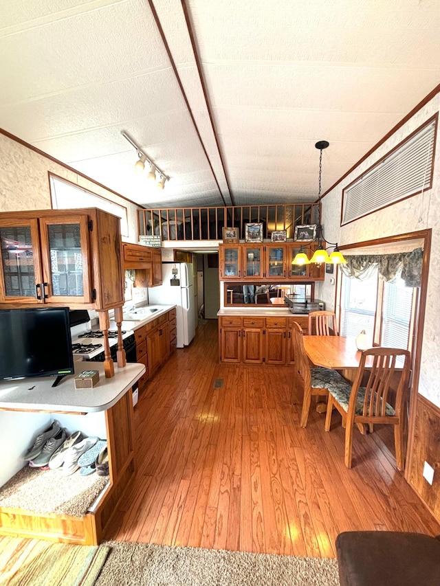kitchen featuring light countertops, white appliances, light wood finished floors, brown cabinetry, and glass insert cabinets