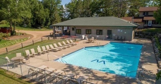 community pool featuring fence and a patio