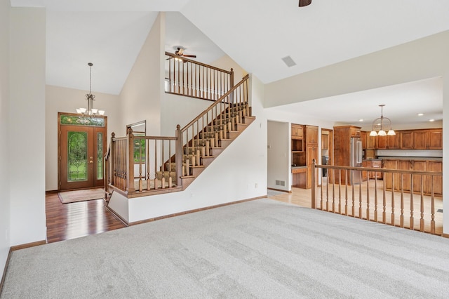 1159 Orwell Ave N, West Lakeland Twp, MN 55082 - unfurnished living room featuring a chandelier, light carpet, high vaulted ceiling, baseboards, and a ceiling fan