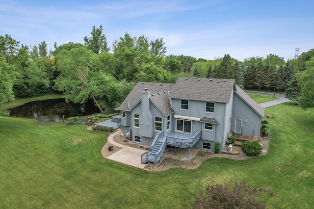 1159 Orwell Ave N, West Lakeland Twp, MN 55082 - rear view of house featuring roof with shingles, a lawn, a patio area, and a water view