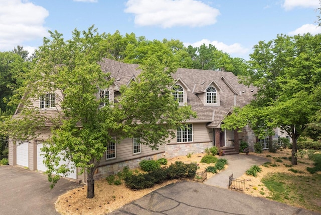 6507 Orchard Ridge Trl, Woodbury, MN 55129 - cape cod-style house featuring stone siding, a garage, and asphalt driveway