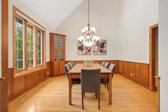 6507 Orchard Ridge Trl, Woodbury, MN 55129 - dining room with a wainscoted wall, light wood finished floors, a chandelier, and lofted ceiling