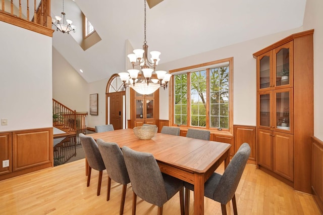 6507 Orchard Ridge Trl, Woodbury, MN 55129 - dining space featuring a chandelier, light wood-style flooring, stairway, wainscoting, and high vaulted ceiling