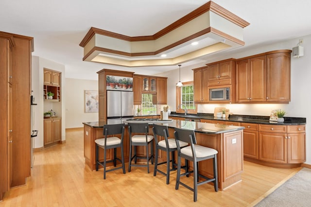 6507 Orchard Ridge Trl, Woodbury, MN 55129 - kitchen with stainless steel appliances, a center island, light wood-style flooring, brown cabinets, and recessed lighting