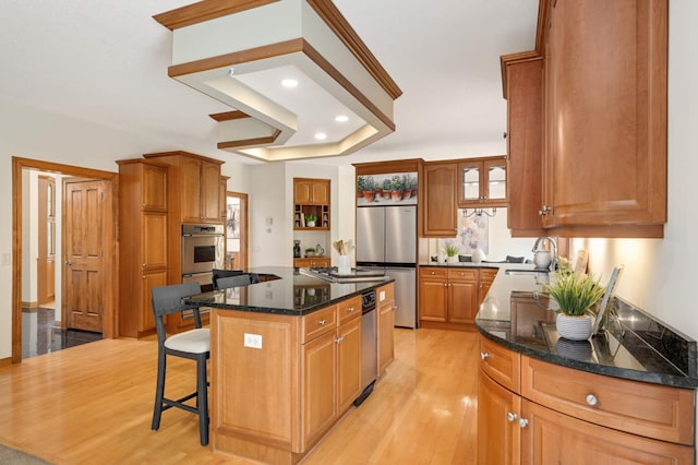 6507 Orchard Ridge Trl, Woodbury, MN 55129 - kitchen with appliances with stainless steel finishes, open shelves, a kitchen bar, light wood-style floors, and a center island