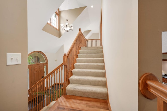 6507 Orchard Ridge Trl, Woodbury, MN 55129 - stairway featuring a high ceiling, a chandelier, and wood finished floors