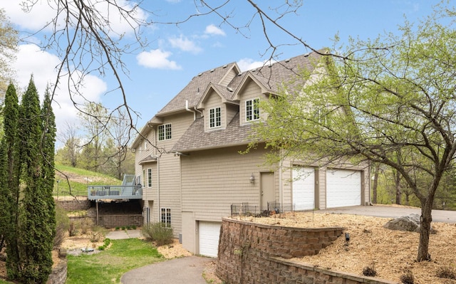 6507 Orchard Ridge Trl, Woodbury, MN 55129 - view of property exterior with a garage, asphalt driveway, a shingled roof, and a deck